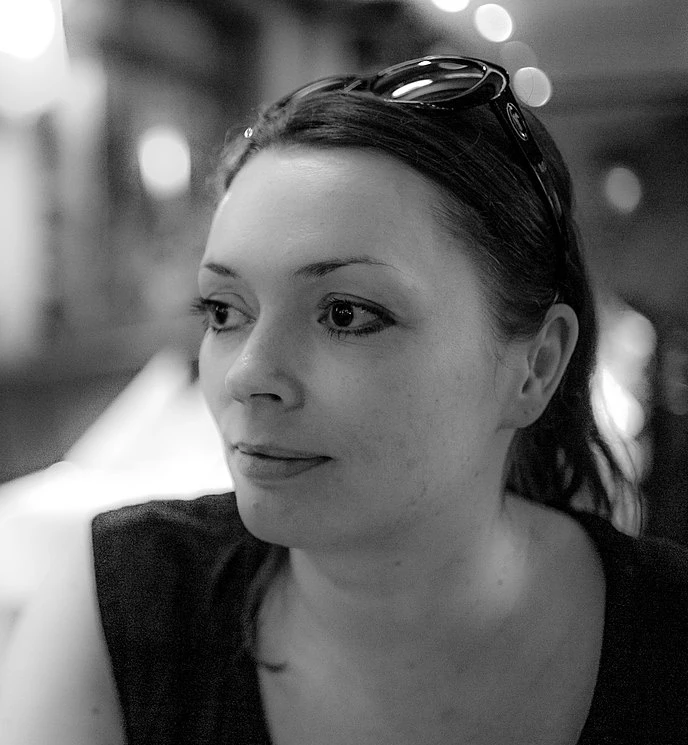 Eine Frau schaut zur Seite. Sie hat eine Sonnenbrille auf dem Kopf. Das Bild ist schwarz-wei&szlig;.